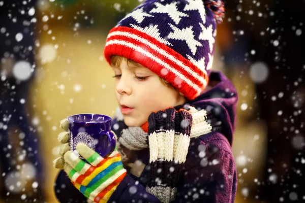 Liten unge pojke dricka varm choklad på julmarknad — Stockfoto