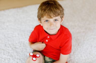 Tri kıpır el Spinner ile kapalı oynayan okul çocuk