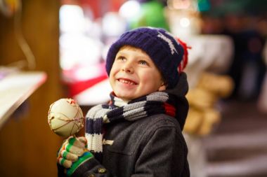 Küçük çocuk çocuk beslenme şeker elma tatlı Noel pazarı üzerinde durmak