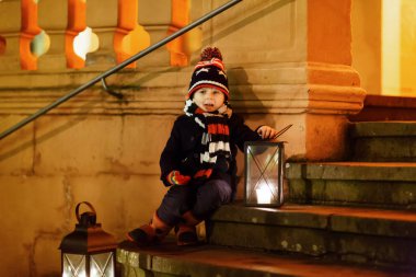 Kilisenin yanındaki merdivenlerde feneri olan sevimli bir çocuk..