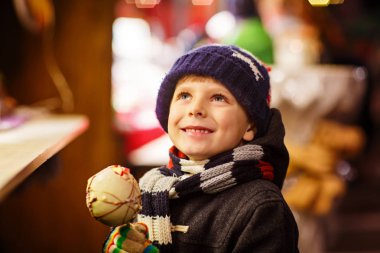 Küçük çocuk çocuk beslenme şeker elma tatlı Noel pazarı üzerinde durmak