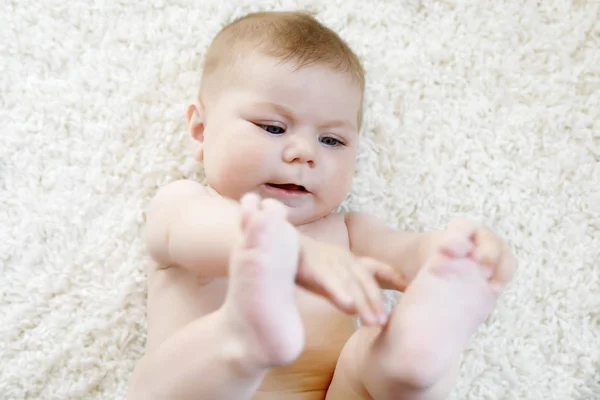 Söt baby flicka som leker med egna fötter. — Stockfoto