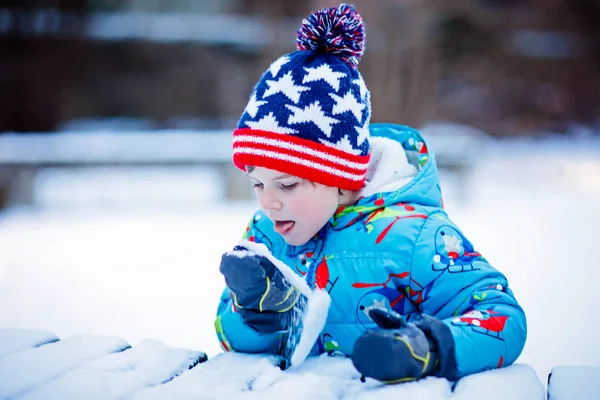 Glad pojke som har kul med snö på vintern — Stockfoto