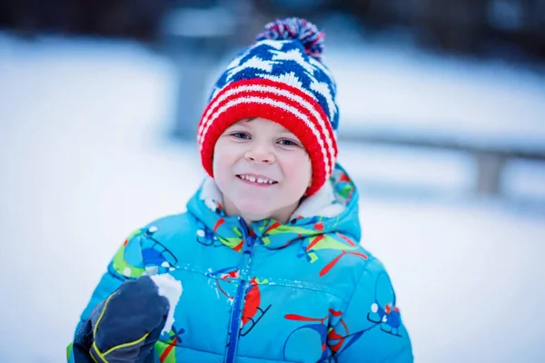 Gelukkig kid jongen hebben plezier met sneeuw in de winter — Stockfoto