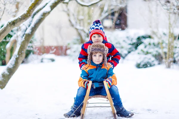 Dos niños pequeños disfrutando de paseo en trineo en invierno — Foto de Stock