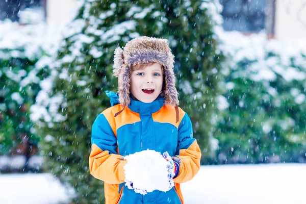 Ευτυχισμένο παιδί που διασκεδάζει με το χιόνι το χειμώνα. — Φωτογραφία Αρχείου