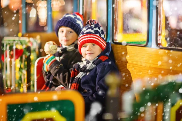 Dvě malý děti chlapci na kolotoč na vánoční trh — Stock fotografie