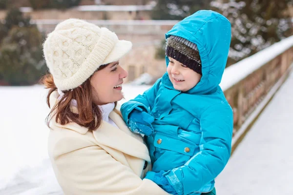 Little toddler kid boy and mother having fun with snow on winter day — Stock Photo, Image