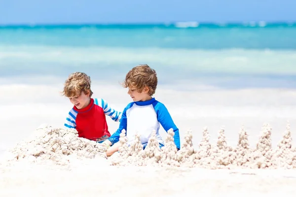 멕시코의 플라야델 카르멘의 열 대 해변에 모래성을 짓고 있는 두 소년 — 스톡 사진