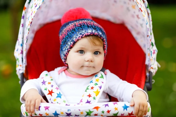 Cute little beautiful baby girl of 6 months sitting in the stylish pram or stroller and waiting for mom — Stock Photo, Image
