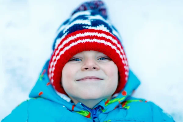 Glücklicher Junge, der im Winter Spaß mit Schnee hat — Stockfoto