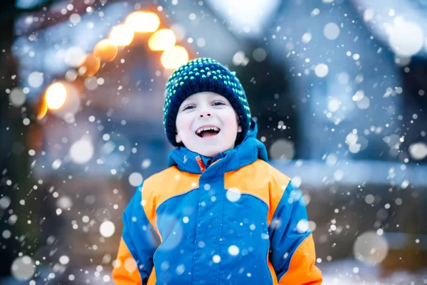 Menino feliz se divertindo com neve no inverno — Fotografia de Stock