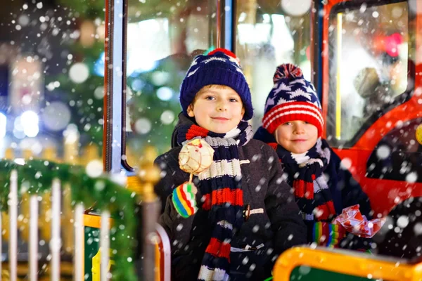 Dois meninos pequenos no carrossel no mercado de Natal — Fotografia de Stock