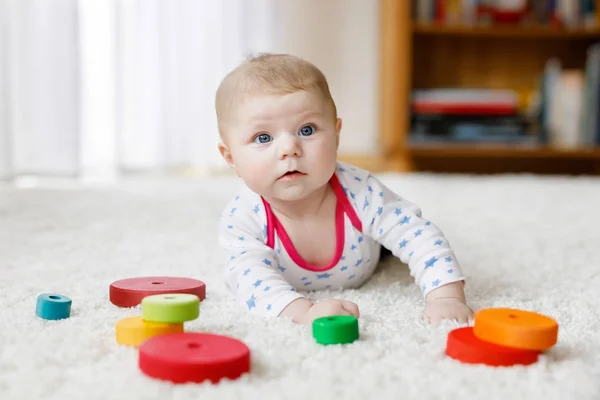 Мила дівчинка грає з барвистою дерев'яною іграшкою — стокове фото