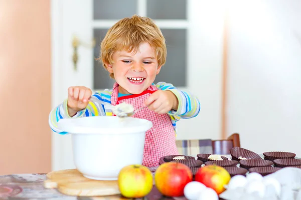 Divertido chico rubio hornear pastel de manzana en el interior —  Fotos de Stock