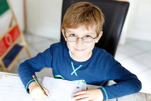 Menino da escola feliz em casa fazendo lição de casa — Fotografia de Stock