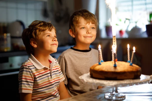 Little kid boys twins celebrating birthday and blowing candles on cake — Stock Photo, Image