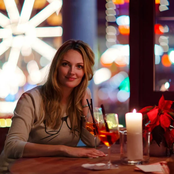 Young woman drining cocktail in restaurant