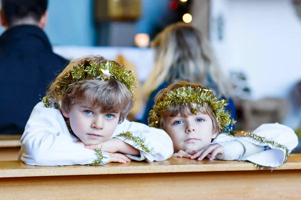 Zwei kleine Jungen spielen Weihnachtsengel in der Kirche — Stockfoto