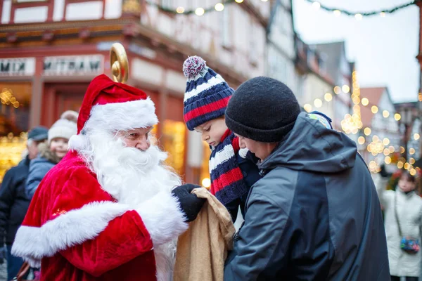 父亲与圣诞老人在圣诞市场上蹒跚学步的小男孩 — 图库照片