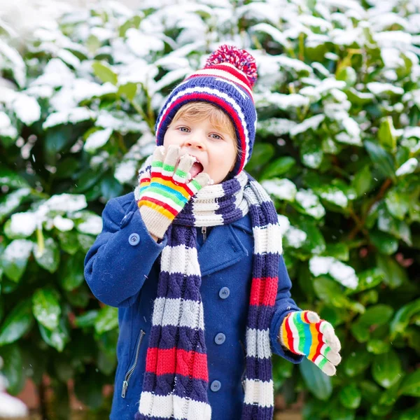 Happy child having fun with snow in winter — Stock Photo, Image