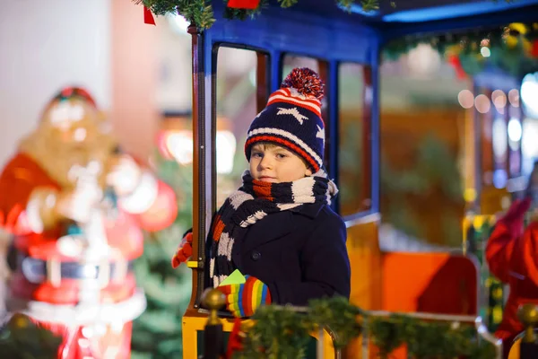 Little kid boy on carousel at Christmas market — Stock Photo, Image