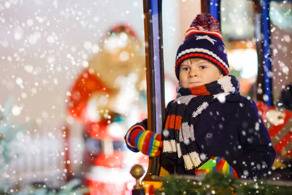 Little kid boy on carousel at Christmas market — Stock Photo, Image