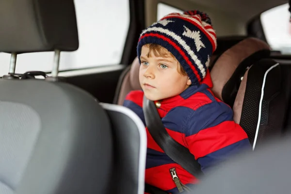 Little kid boy sitting in safety car seat during trip — Stock Photo, Image