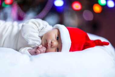Noel ağacı yakınındaki Santa şapkalı bir hafta eski yeni doğan bebek