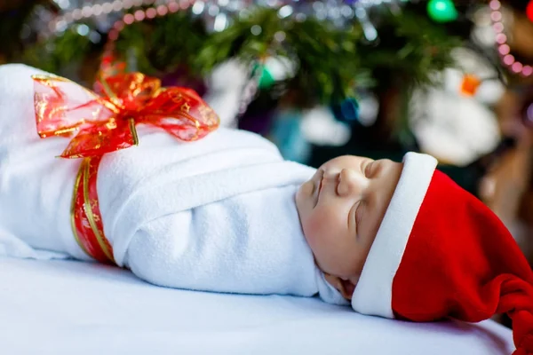 Een week oud pasgeboren baby gewikkeld in een deken in de buurt van de kerstboom — Stockfoto