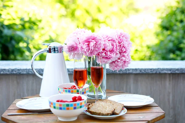 Breakfast table with bread, frest vegetables and berries, coffee and champagne served on balkony or hotel on summer morning — Stock Photo, Image