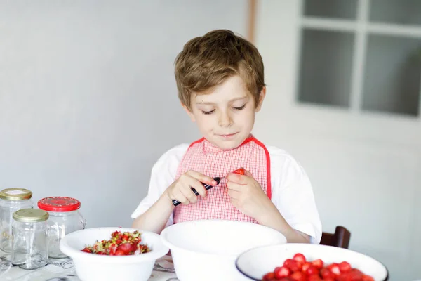 Little blond kid boy helping and making strawberry jam in summer — Stock Photo, Image