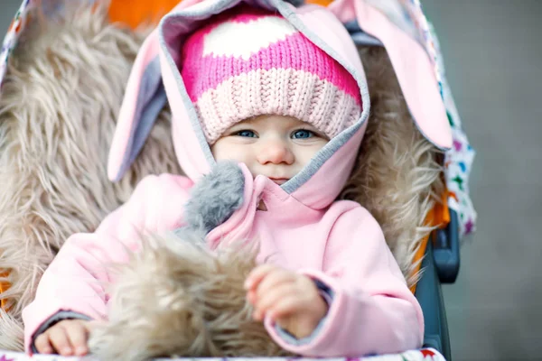 Sevimli küçük güzel bebek kız çocuk arabası veya bebek arabası sonbahar gününde oturan