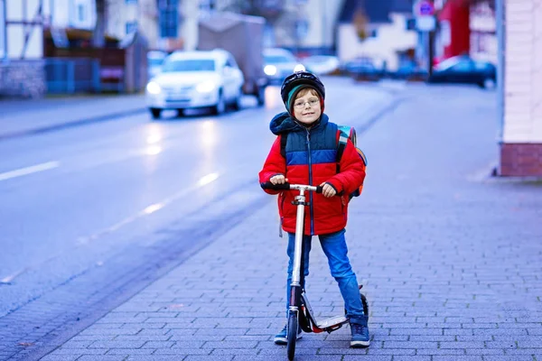 Cute little kid boy riding on scooter on way to school — Stock Photo, Image