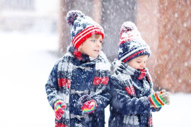 Mutlu çocuklar kışın karla eğleniyor.