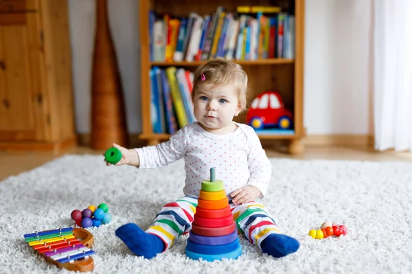 Adorable cute beautiful little baby girl playing with educational colorful wooden rainboy toy pyramid — Stock Photo, Image