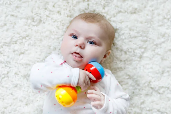 Schattig baby meisje spelen met kleurrijke rammelaar speelgoed — Stockfoto