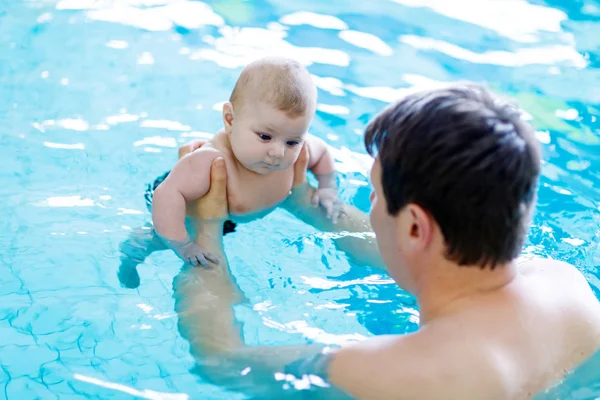Feliz padre de mediana edad nadando con lindo bebé adorable en la piscina . — Foto de Stock