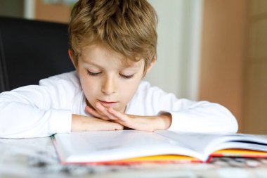 Küçük sarışın okul çocuk çocuk evde kitap okurken