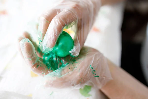 Primer plano de manos adultas para colorear huevos de Pascua con colores —  Fotos de Stock