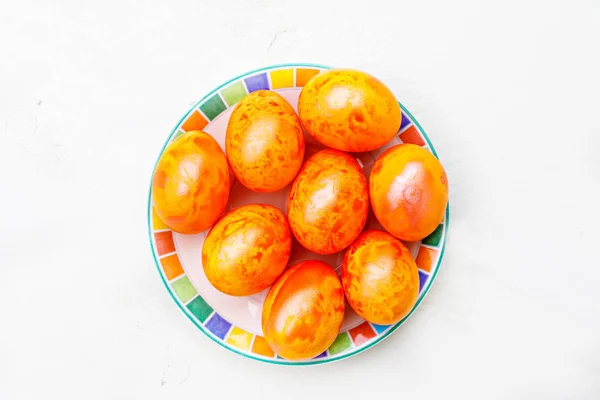 Easter eggs on wooden background. Colorful eggs in different colors - red, yellow, orange, purple and green. — Stock Photo, Image