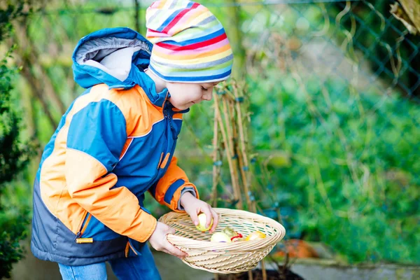 Sevimli sevimli küçük çocuk çocuk yumurta avlamak üstünde Paskalya yortusu yapma. — Stok fotoğraf