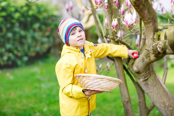 Roztomilý rozkošný malý dítě chlapec dělat hon na velikonoční vajíčka. — Stock fotografie