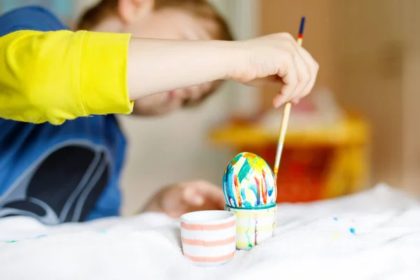 Close-up of little kid hands coloring eggs for Easter holiday — Stock Photo, Image