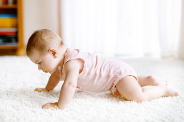 Küçük komik kız cesedi kaldırıyor ve emeklemeyi öğreniyor..