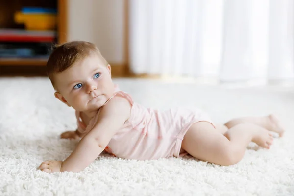 Pouco engraçado bebê menina levantando corpo e aprender a rastejar. — Fotografia de Stock