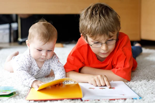 Baby girl and school kid boy reading books at home. — Stock Photo, Image