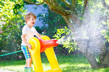 bir bahçe hortumu su yağmurlama ile oynarken küçük çocuk çocuk