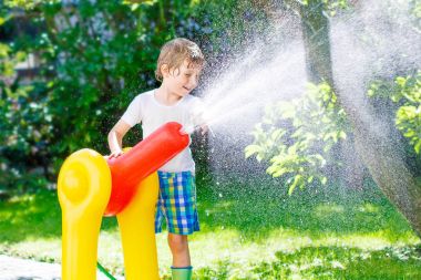 bir bahçe hortumu su yağmurlama ile oynarken küçük çocuk çocuk