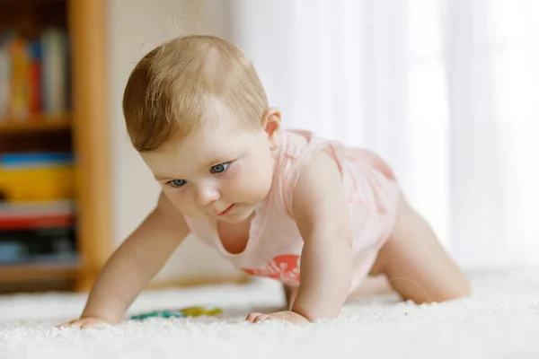 Kleine lustige Babymädchen heben Körper und lernen zu kriechen. — Stockfoto